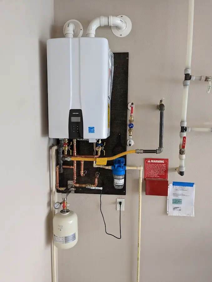 Professional plumber installing copper piping in a Massac home